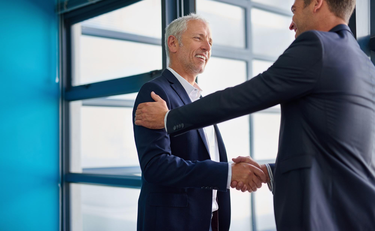 Consolidated Wealth | its great have you board cropped shot two businessmen shaking hands lobby